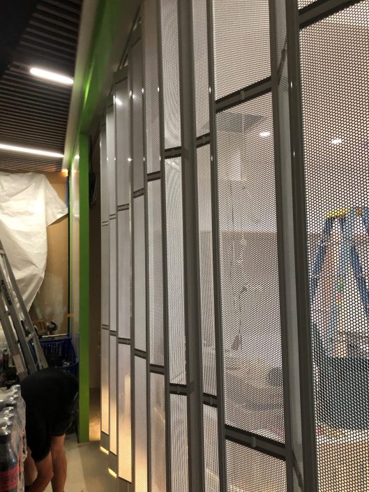 Perforated Mesh Infill Retail Folding Doors for Le Wrap Australia